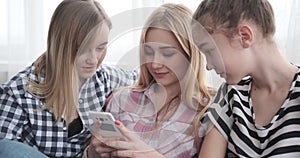 Teenage girls watching social media content on mobile phone