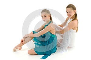 Teenage Girls in White and Blue Sport Dresses Sitting on the Flo