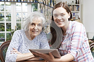 Teenage Granddaughter Showing Grandmother How To Use Digital Tab