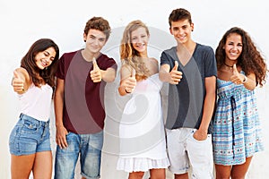 Teenage Group Leaning Against Wall Giving Thumbs Up