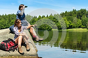 Teenage hikers birdwatching at lake