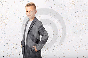 Teenage kid wearing cool jacket standing in empty room, copy space on white wall