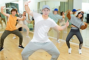 Teenage krump dancer dancing with teenagers in choreographic studio