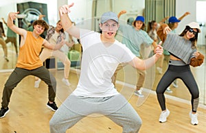 Teenage krump dancer dancing with teenagers in choreographic studio