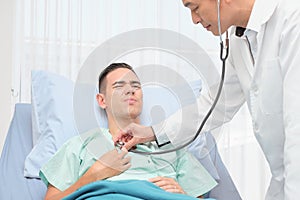 Teenage Male Patient on bed  in hospital room ,diagnosing by the doctor