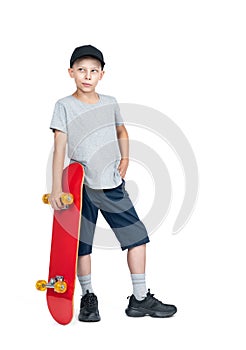 A teenage man in shorts, T-shirt, cap standing holding a red skateboard in his hand, isolated on a white background.
