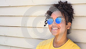 Teenage mixed race African American girl young woman wearing sunglasses reflecting blue sky and clouds