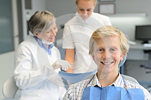 Teenage patient, dentist woman with dental assistant