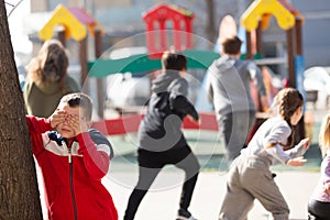 Teenage playing hide-and-go-seek in the playground