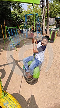 Teenage playing with tyre ring swings
