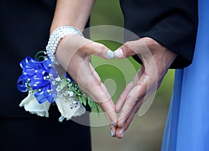 Teenage Prom Couple Forming Hand Heart Between Them