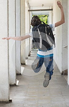 Teenage school boy with a backpack on his back walking to school