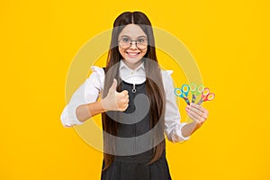 Teenage school girl with scissors, isolated on yellow background. Child creativity, arts and crafts.