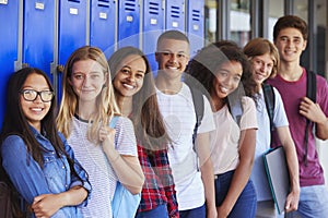 Teenage school kids smiling to camera in school corridor