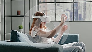 Teenage schoolgirl shows OK symbol moves hands in VR glasses