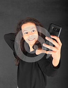 Teenage schoolgirl taking selfie on smartphone