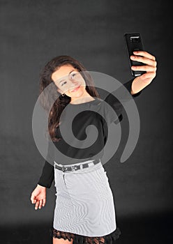 Teenage schoolgirl taking selfie on smartphone