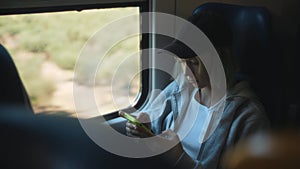 Teenage with smartphone inside the train.