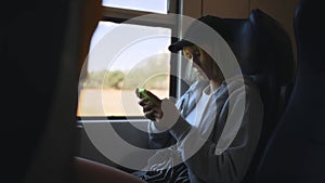 Teenage with smartphone inside the train.