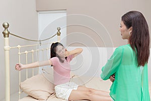 Teenage girl stretching in bed after wake up