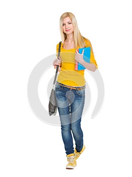 Teenage student girl with books going forward