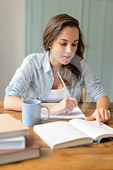 Teenage student girl studying book at home