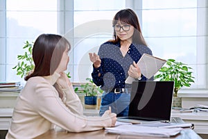 Teenage student studying at desk with computer, trainer mentor helping teaching