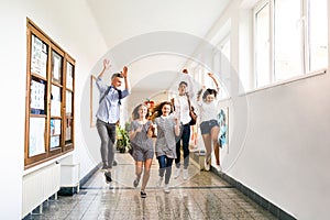 Teenage students in high school hall jumping high.