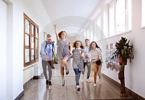 Teenage students in high school hall jumping high.