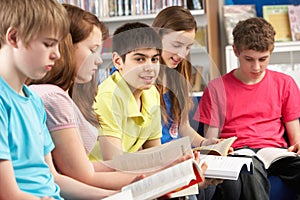 Teenage Students In Library Reading Books