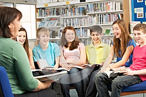 Teenage Students In Library Reading Books