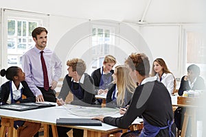 Teenage Students Listening To Teacher In Art Class