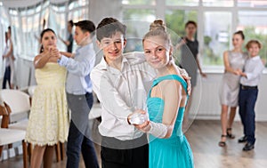 Teenage students rehearsing ballroom dance while preparing for college festive event