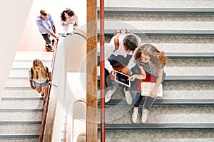 Teenage students on stairs in high school.