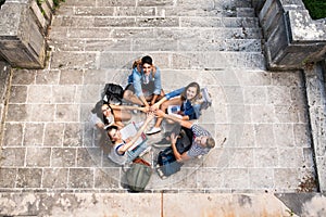 Teenage students at the stone steps in front of university.