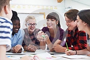 Teenage Students With Teacher In Biology Class