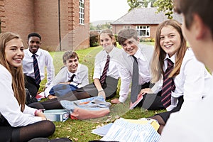 Teenage Students In Uniform Working On Project Outdoors