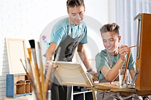 Teenage twin brothers having painting class in workshop