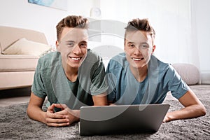 Teenage twin brothers using laptop together