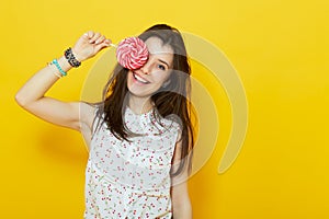 Teenage woman smiling and holding a lollipop