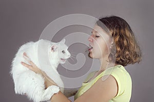 A teenaged allergic girl holds a angora cat