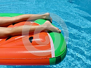 Teenaged boy floating in a swimming pool in an inflatable ring