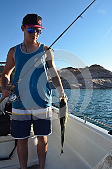 Fishing Teenaged boy holding striped bass