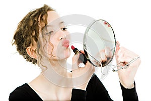 Teenaged girl in black dress making make up in round mirror - lipstick
