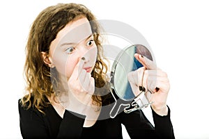Teenaged girl checking skin in mirror - nose