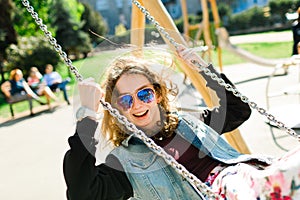 Teenaged Girl with sun glasses swinging