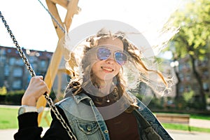 Teenaged Girl with sun glasses swinging