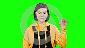 Teenager advertises a product and shows okay. Green screen