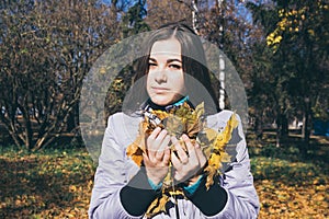 Teenager and the armful of yellow autumn leaves