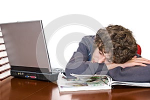 Teenager asleep studying for examination